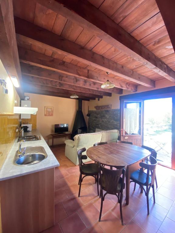 Una cocina y una sala de estar con mesa y sillas. en Can Bonada, en El Serrat