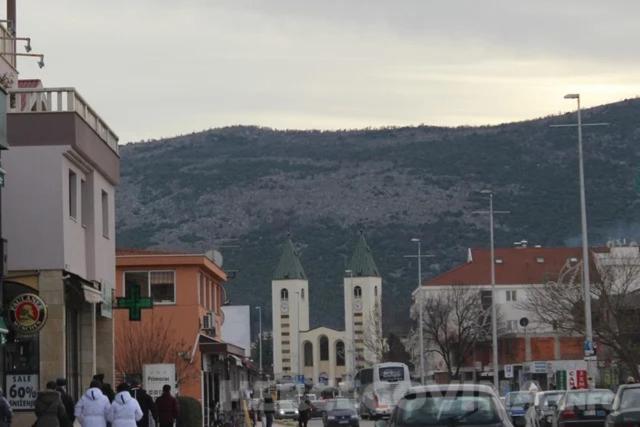 un grupo de personas caminando por una concurrida calle de la ciudad en Hotel Holy en Međugorje