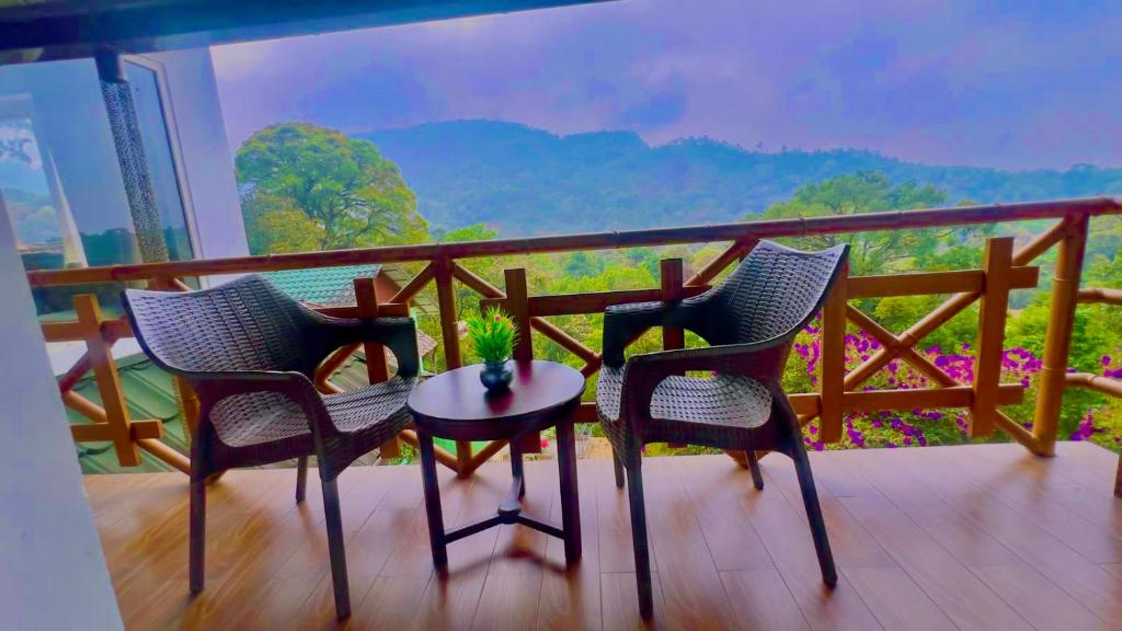 2 sillas y mesa en un balcón con vistas en Nature Valley Resort, Lap of Nature Munnar, en Munnar