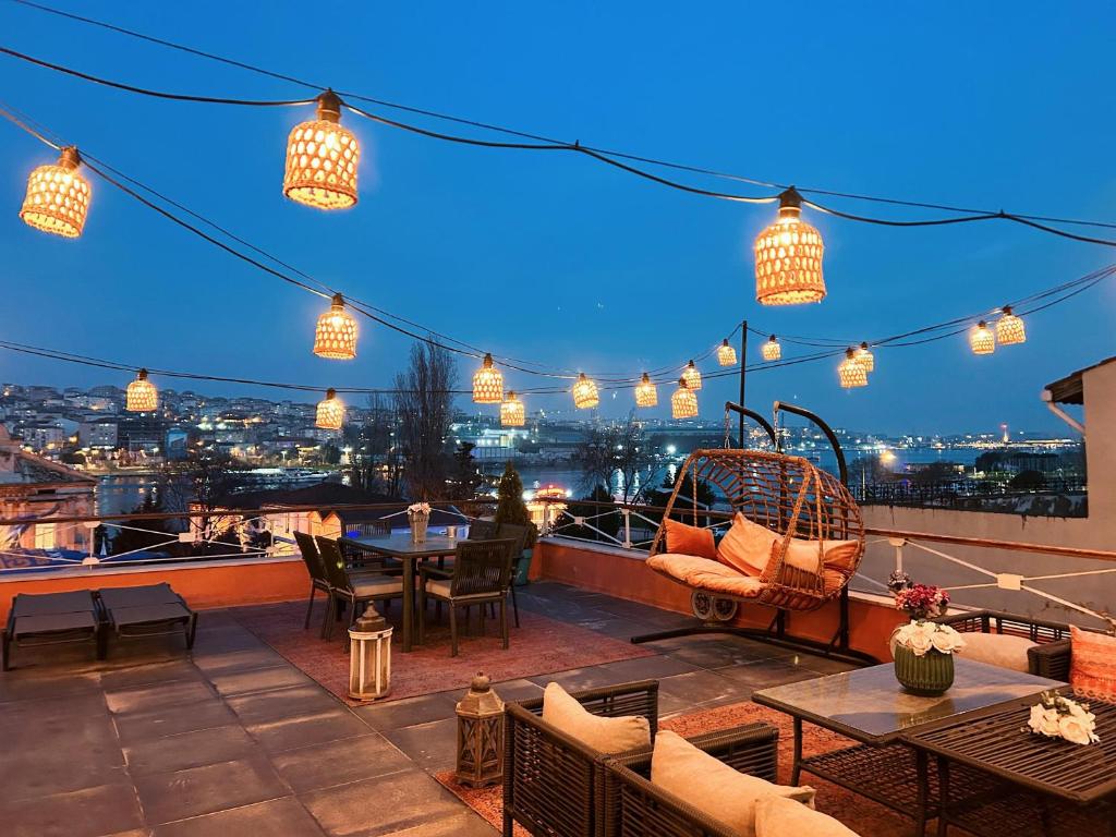 a rooftop patio with tables and chairs and lights at Waterfront Terrace House Bosphorus Istanbul in Istanbul