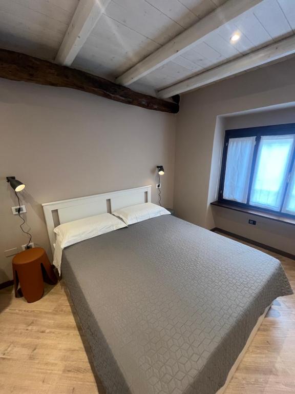 Un dormitorio con una cama grande y una ventana en LA RONDINE, en Pettenasco