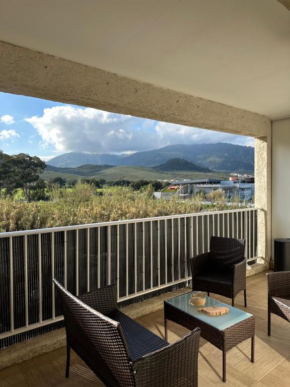 un balcon avec des chaises et une table et une vue dans l'établissement Appartement T2 - Vue Montagne, à Biguglia