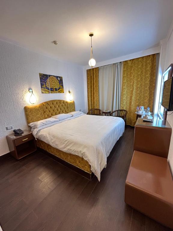 een hotelkamer met een groot bed en een bureau bij Oasis Hotel Heliopolis in Caïro