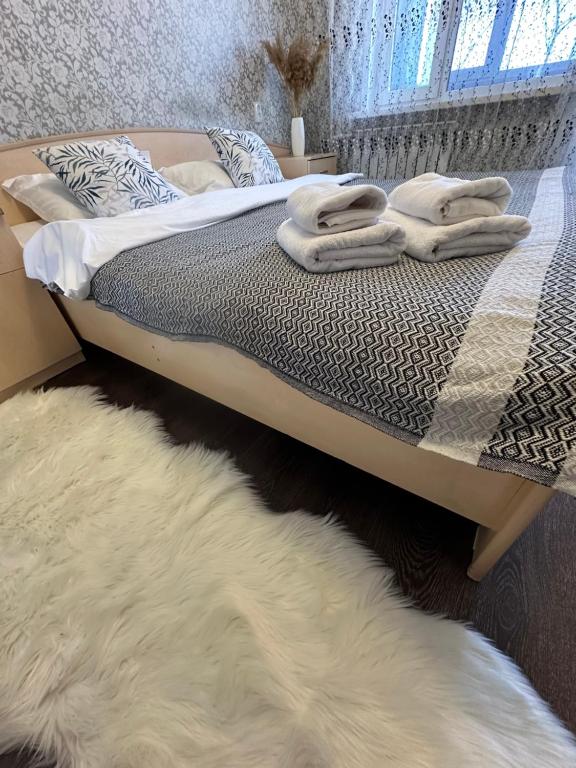 1 dormitorio con 1 cama con toallas en Квартира по Республике 16/2, en Karagandá
