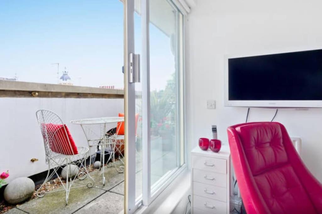 Zone 1! 2 bed duplex Apartment! في لندن: غرفة معيشة مع تلفزيون وكرسي احمر