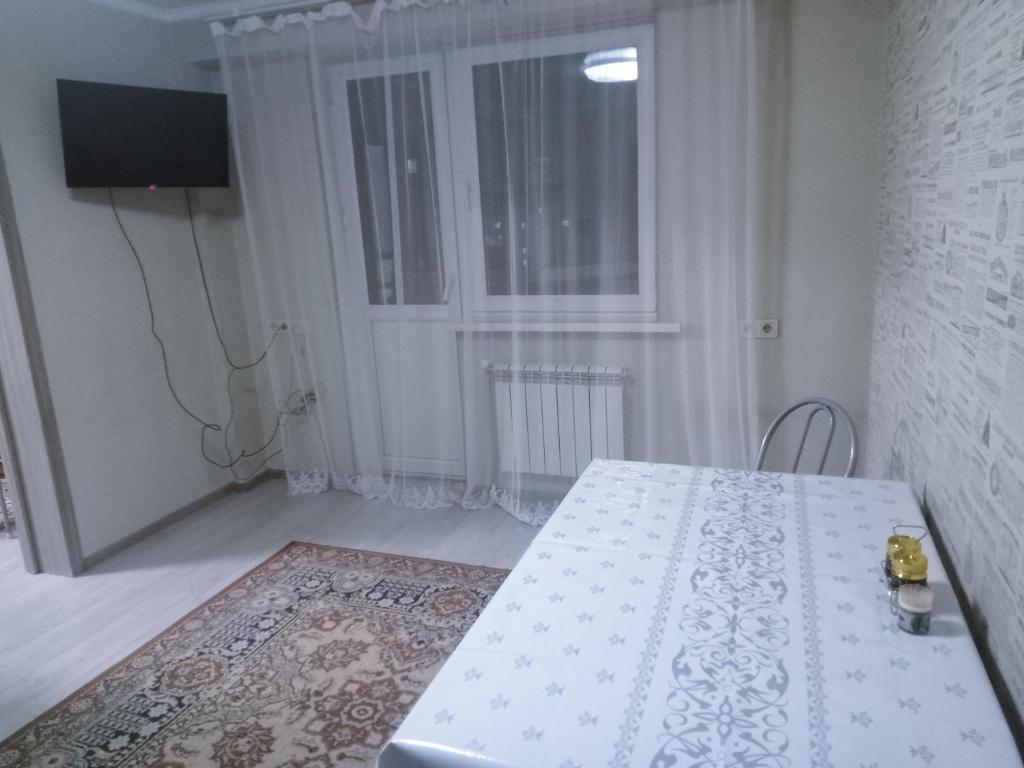 a white room with a table and a window at Уют в сердце Алматы in Almaty
