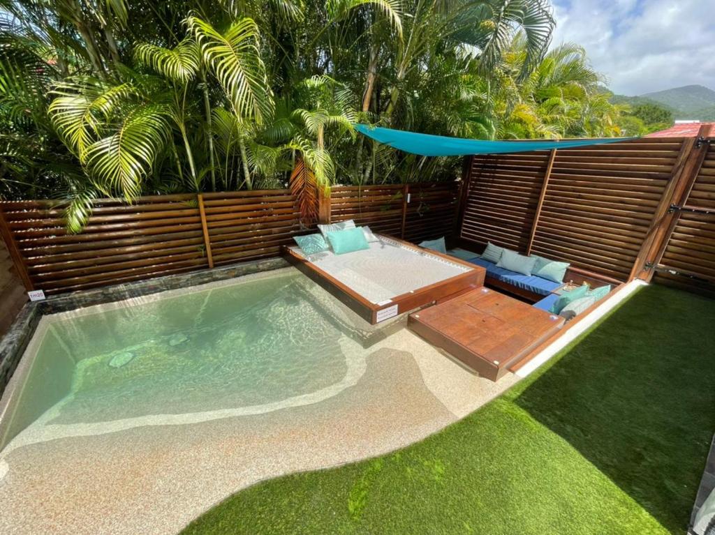 a backyard with a swimming pool and a umbrella at Kawan Bay Suites in Deshaies