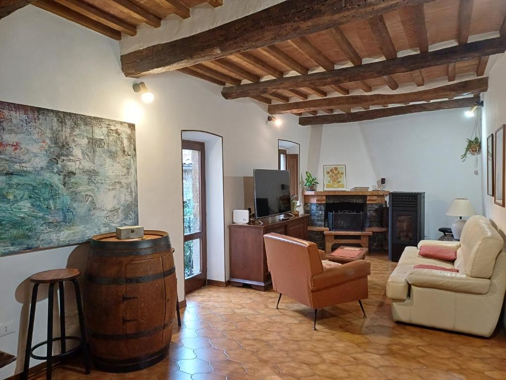 a living room with a barrel and a couch and chair at casa il Girasole Pitigliano in Pitigliano