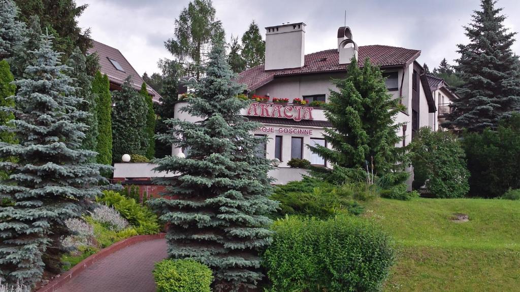 una gran casa blanca con árboles delante de ella en Pokoje Gościnne Akacja, en Polanica-Zdrój