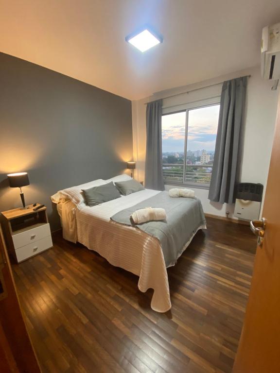 ein Schlafzimmer mit einem Bett und einem großen Fenster in der Unterkunft Avenida 38 Confort y Relax. Estadio Único, Hospital Español in La Plata