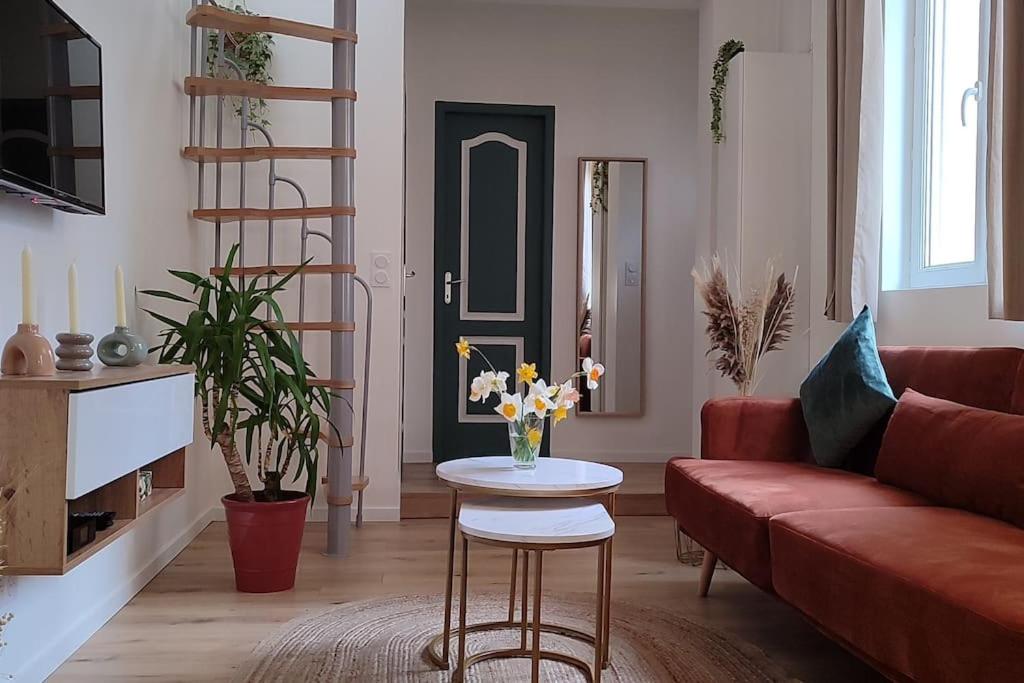 - un salon avec un canapé rouge et une table fleurie dans l'établissement Maison cosy terrasse ensoleillé, à Clermont-Ferrand