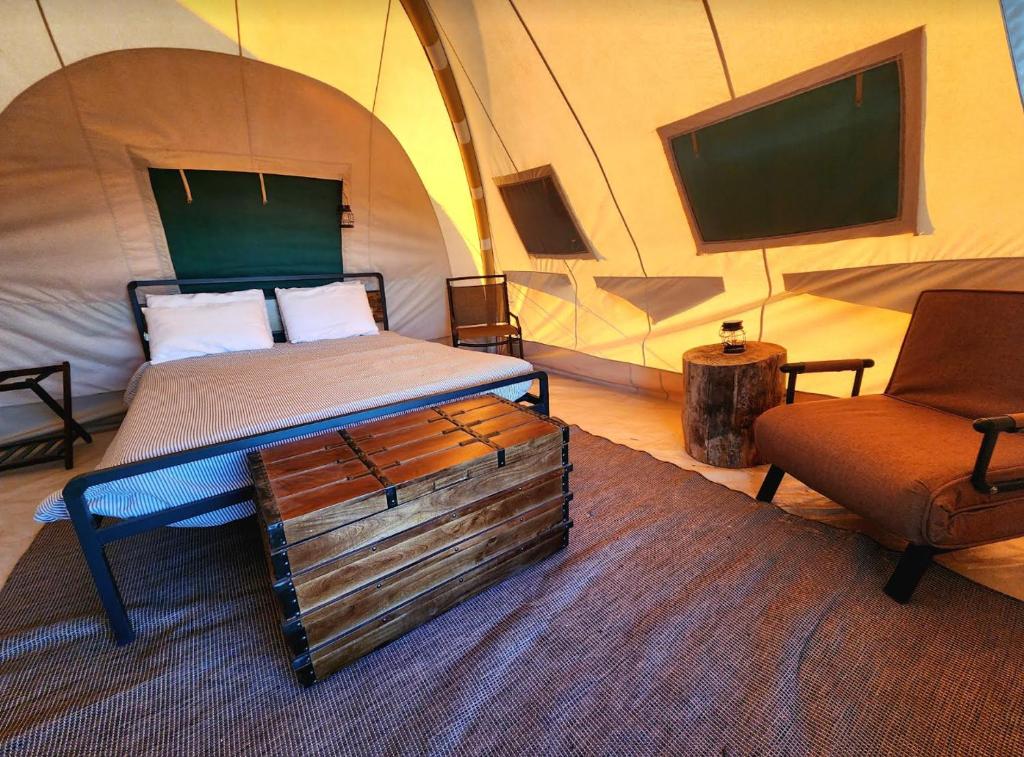 a bedroom with a bed and a chair in a tent at Kestrel in Valle