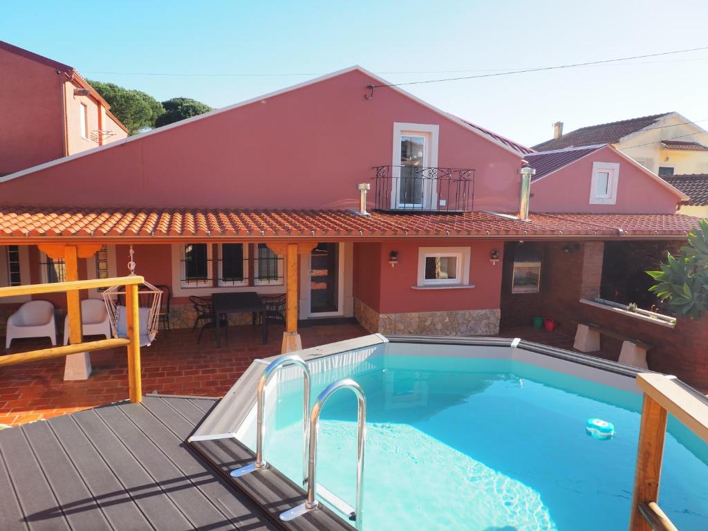a house with a swimming pool in front of a house at Casa da Venda do Marco in Caldas da Rainha