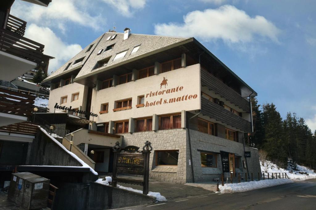 a building with a sign on the side of it at Hostel San Matteo in Santa Caterina Valfurva