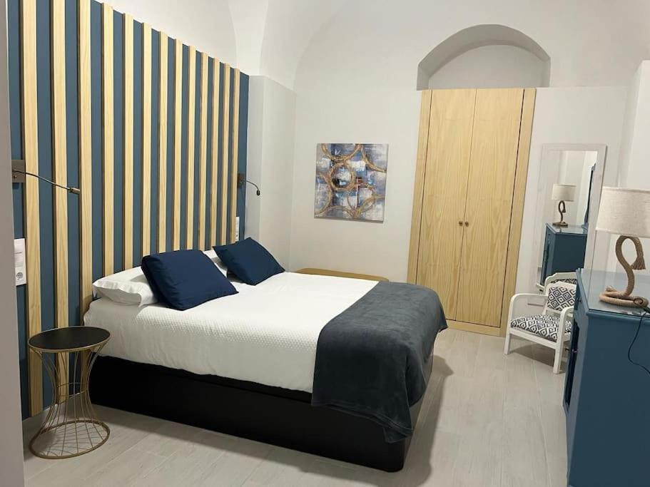 1 dormitorio con 1 cama grande con almohadas azules en Apartamento Las Bóvedas, en Cáceres