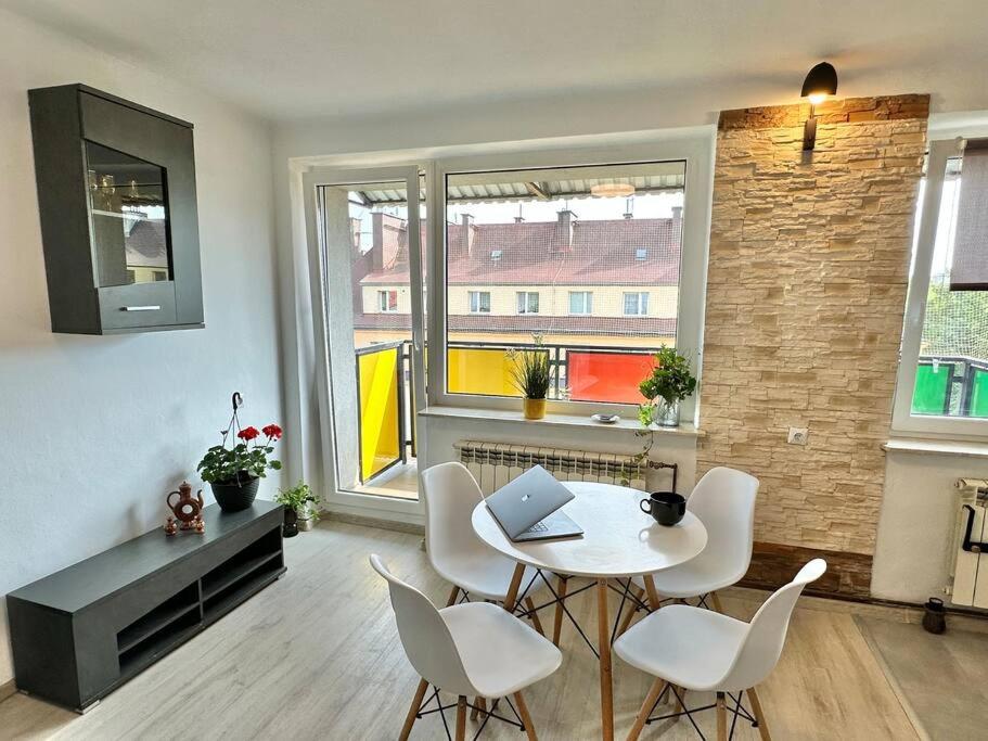 sala de estar con mesa, sillas y ventana en Sunny Apartment in Silesia, en Czeladź