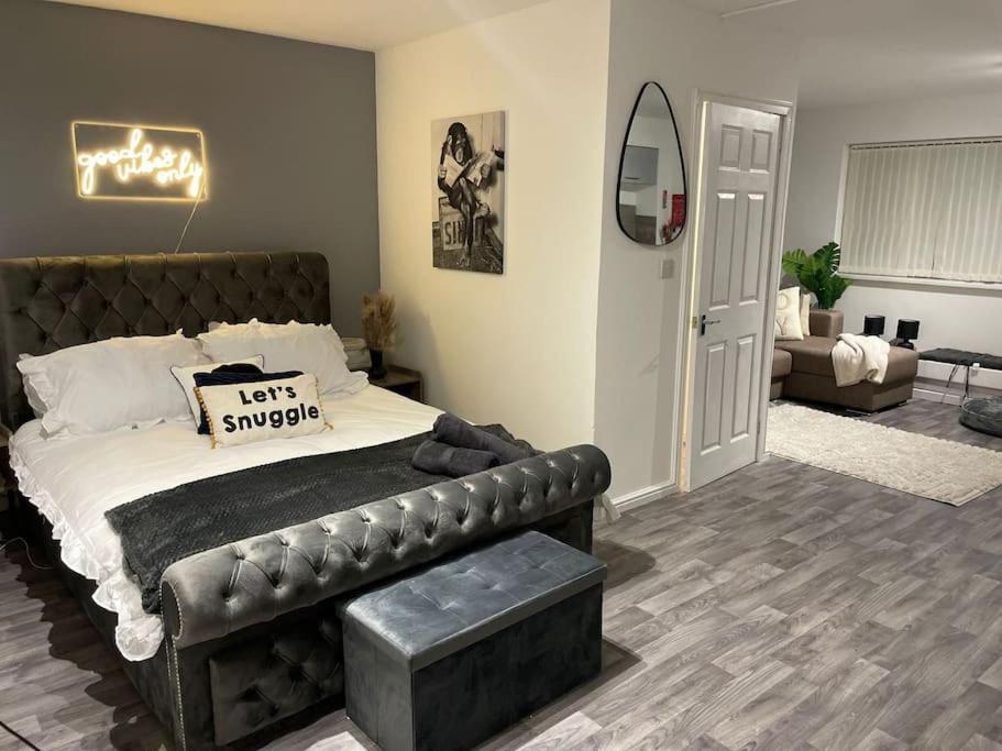 a bedroom with a leather bed and a living room at Cosy Studio 6 with Free Parking in Birmingham