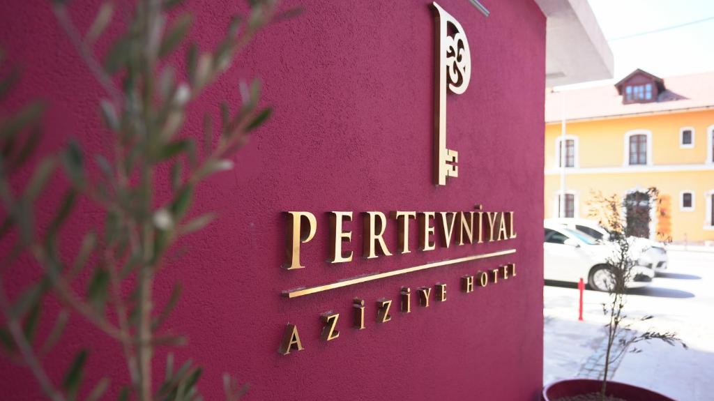 um edifício vermelho com um cartaz que lê "Peryrlivina" uma sala de estar. em Pertevniyal Aziziye Hotel em Konya