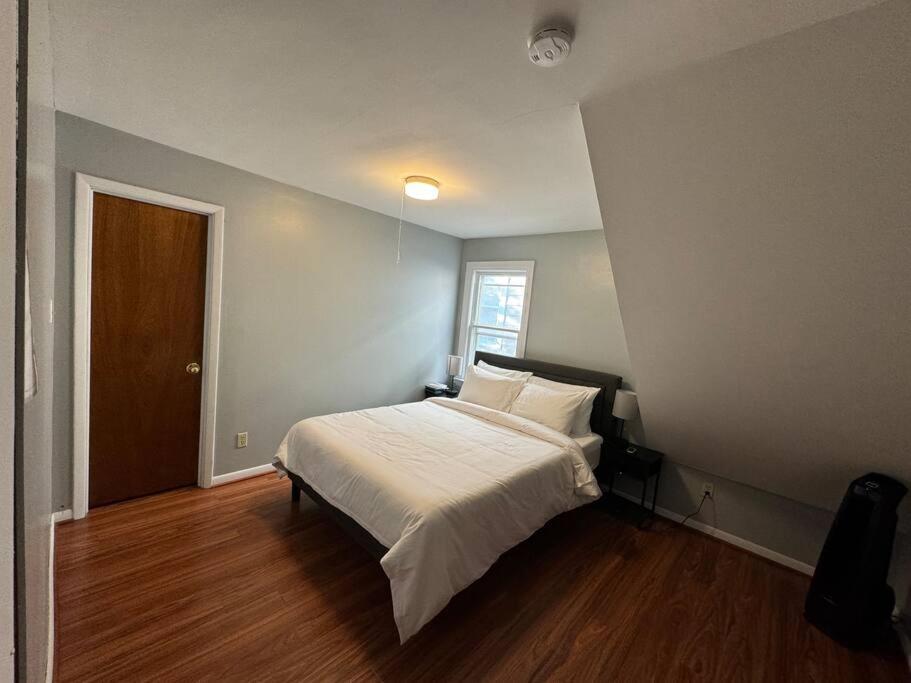 a bedroom with a bed with white sheets and a window at Comfy getaway full Apt single bedroom sleeps two! in Niagara Falls