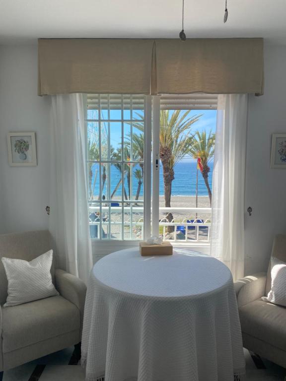 una mesa blanca con vistas a la playa en Apartamento en Primera Linea, en La Herradura