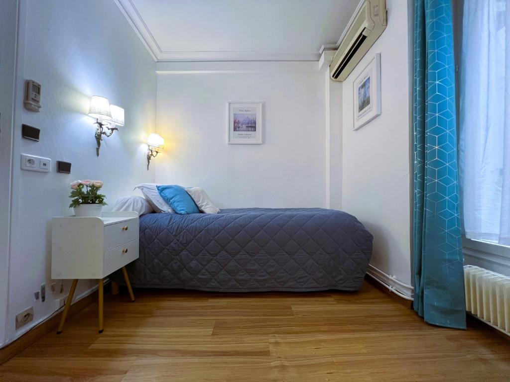 a small bedroom with a bed and a night stand at Hôtel La Sanguine in Paris