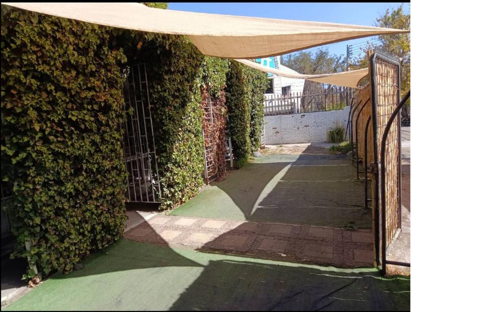 an entrance to a building with a fence and an umbrella at Casa Providencia 8 personas vive la ciudad y naturaleza in Santiago