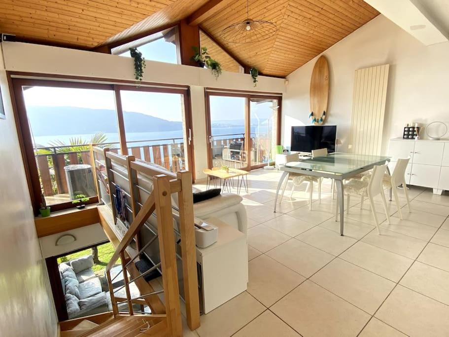 d'un salon avec une table et un balcon. dans l'établissement Duplex avec jardin, superbe vue lac, Veyrier, à Veyrier-du-Lac