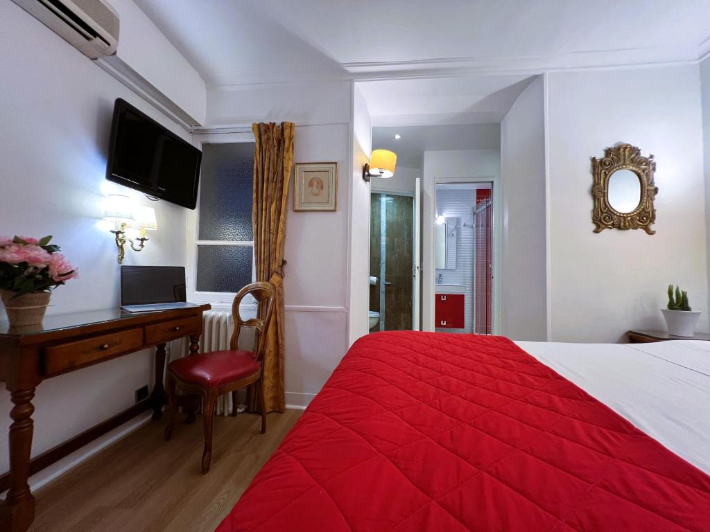 a hotel room with a red bed and a desk at Hôtel La Sanguine in Paris