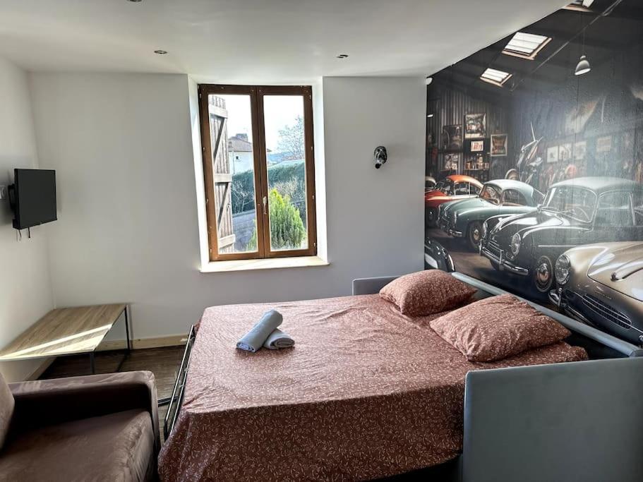 ein Schlafzimmer mit einem Bett mit einem Wandbild für Autos in der Unterkunft Le Garage de Cuba in Épinal