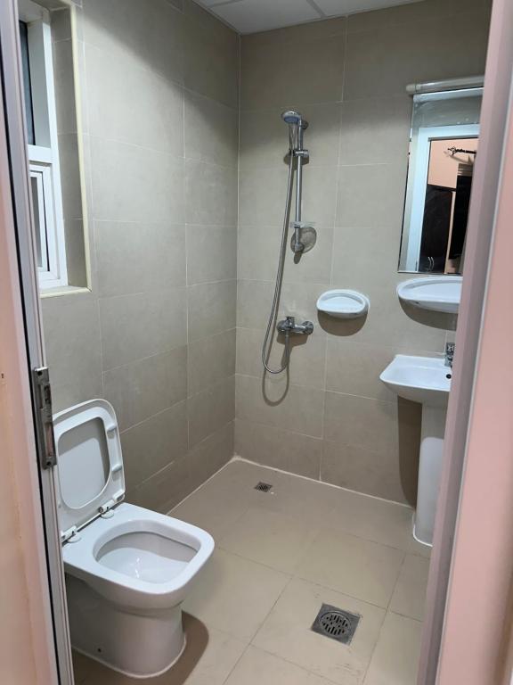 y baño con aseo y lavamanos. en Palm Inn Hostel 2024, en Dubái