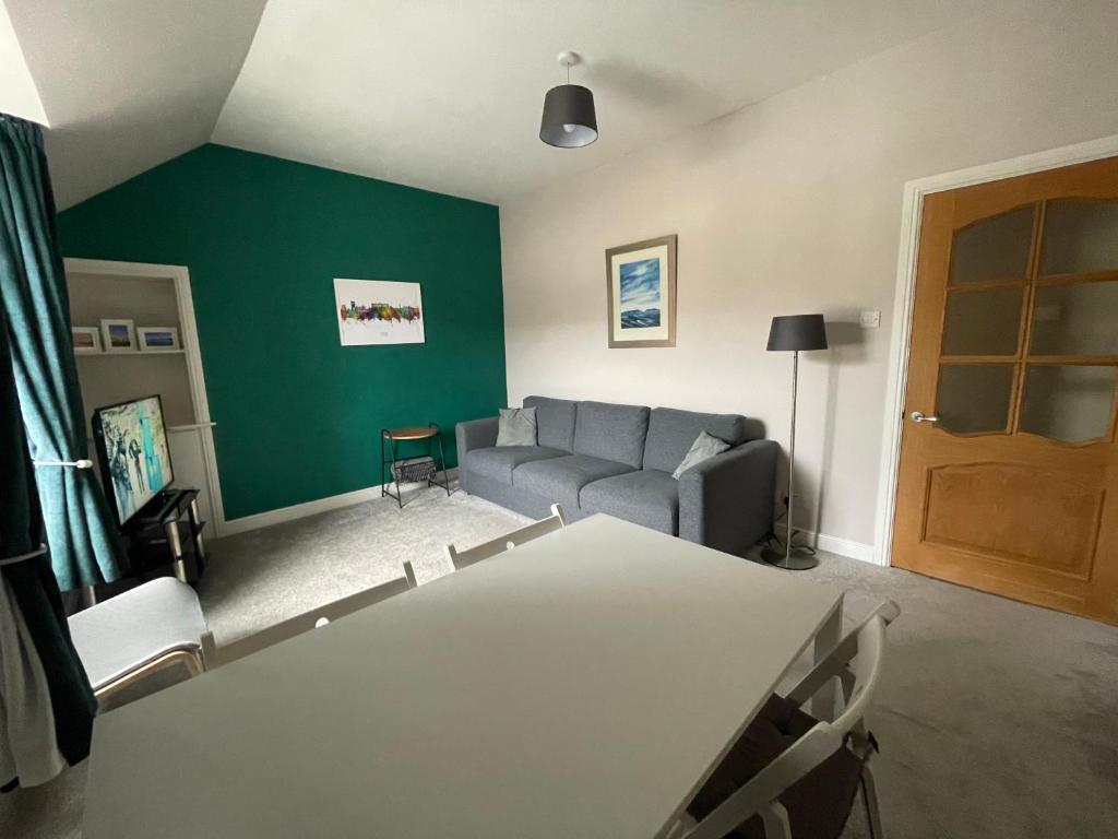 uma sala de estar com um sofá e uma mesa em Carronvale. 3 Bedroom Oban Apartment. em Oban