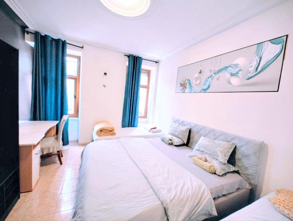a bedroom with a large bed and a desk at The ARK Eco Homestay in Esch-sur-Alzette