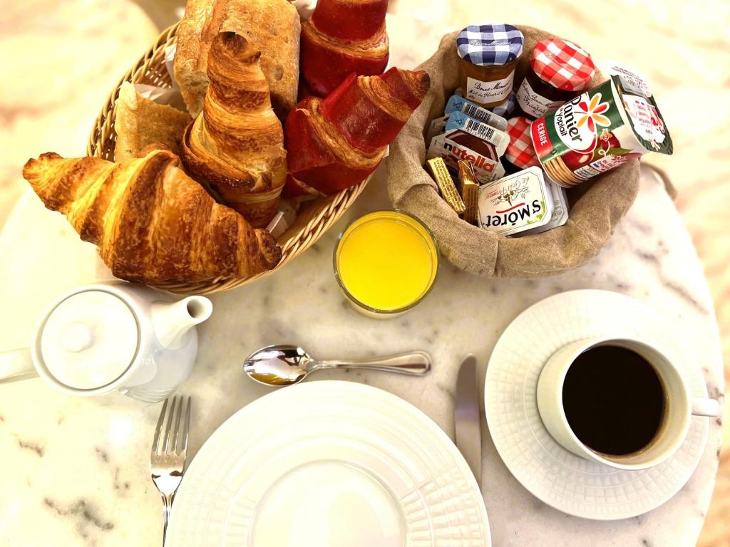 a breakfast table with a basket of bread and coffee at Hôtel La Sanguine in Paris