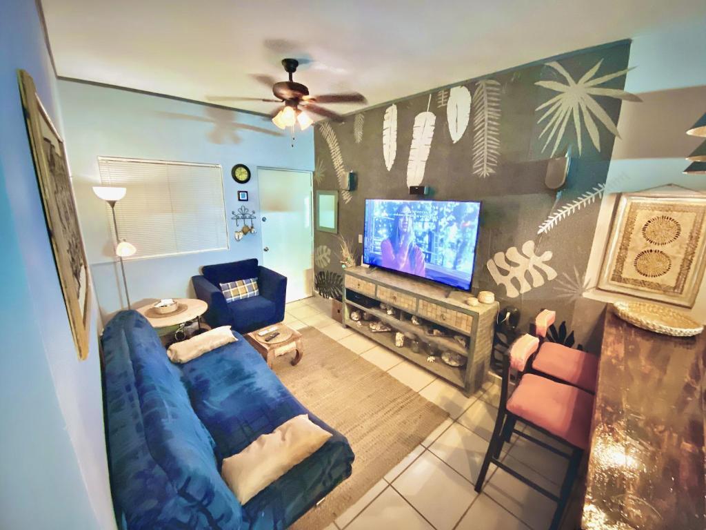 a living room with a blue couch and a tv at Modern 1-bedroom Apartment in Cabo San Lucas in Cabo San Lucas