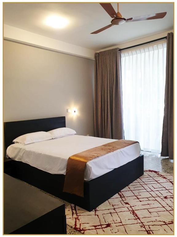 1 dormitorio con 1 cama y ventilador de techo en Orange Guest Homes & Banquet Hall, en Serukele