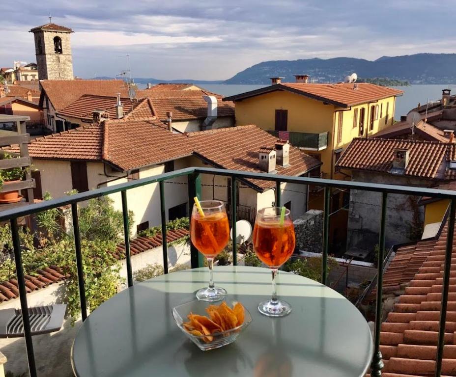 two glasses of wine sitting on a table on a balcony at Dependance Pesce d'Oro in Verbania