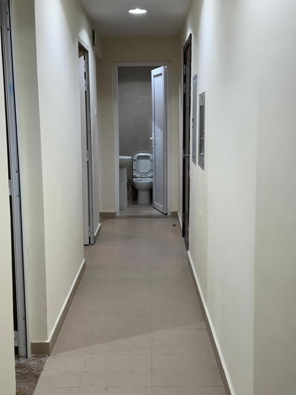 a hallway of a bathroom with a toilet in it at Palm Inn Hostel in Dubai