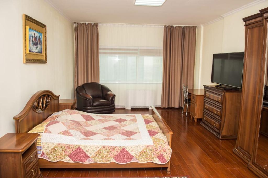 a hotel room with a bed and a television at SEVER 555 in Astana