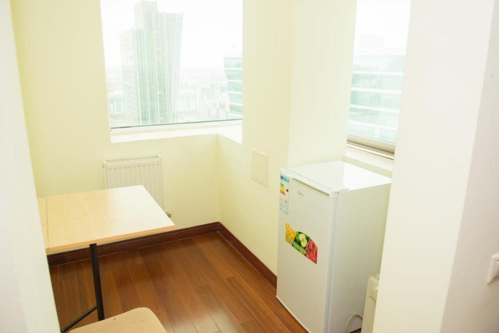 a small room with a refrigerator and a table at SEVER 555 in Astana