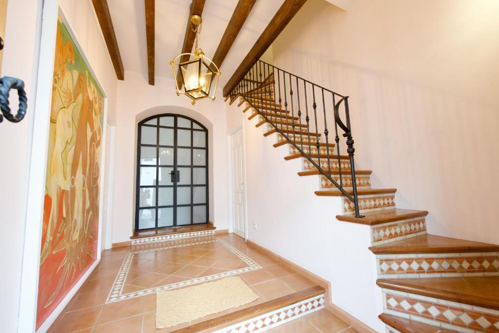 a hallway with stairs and a chandelier at Casa Rural Sierra Morena in Cazalla de la Sierra