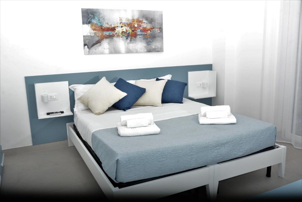 a bedroom with a bed with blue and white pillows at Seaway Accommodation " Private Parking " in Tropea