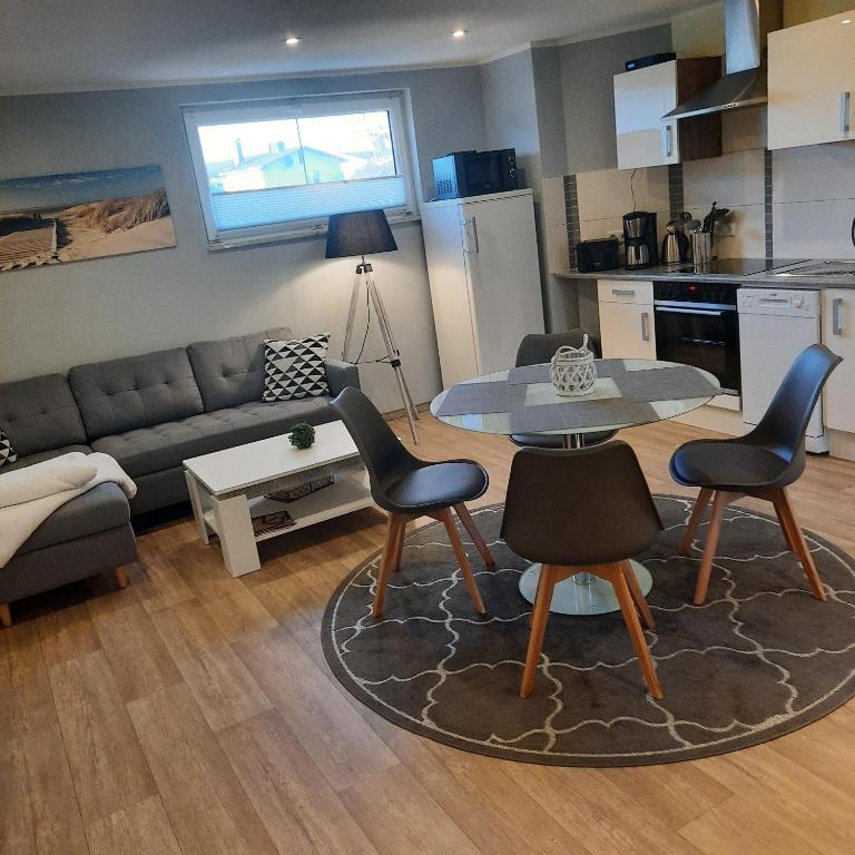 a living room with a couch and a table and chairs at Theunis Ferienwohnung in Karlshagen