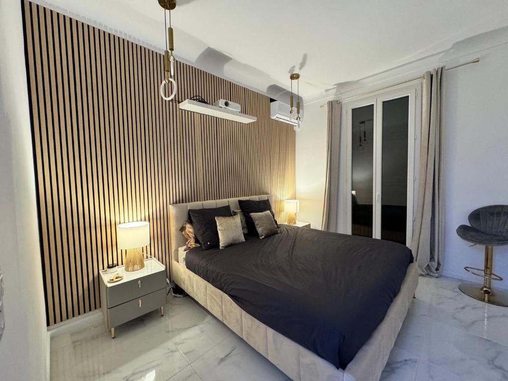 une chambre avec un lit et une table de chevet avec des lampes dans l'établissement Appartement vue mer vue Monaco, à Beausoleil