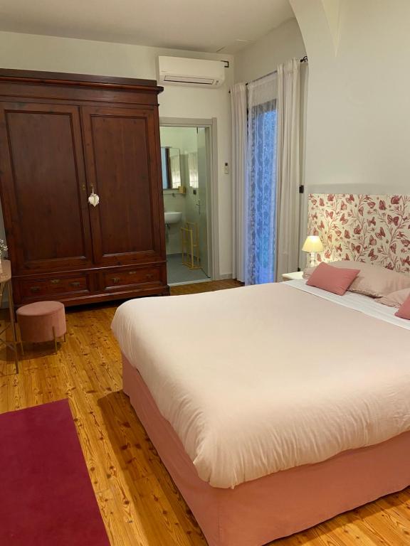 a bedroom with a large white bed and a cabinet at Victoria House B&B in Pisa