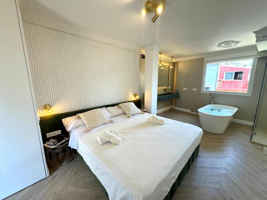 a bedroom with a large bed and a bath tub at Luxury Cathedral Views in Seville in Seville