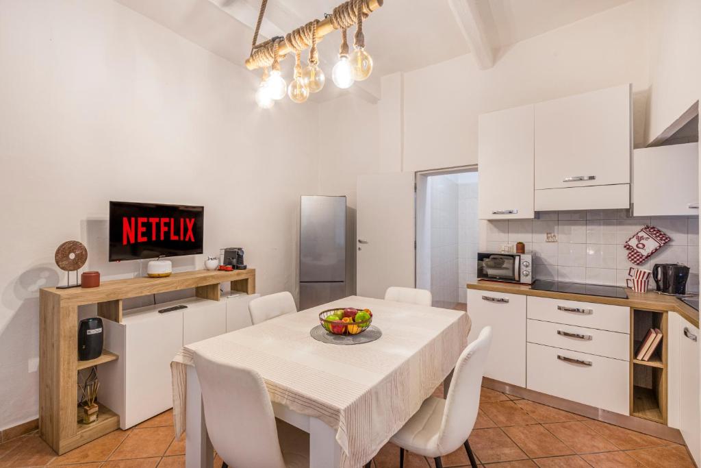 une cuisine et une salle à manger avec une table et des chaises dans l'établissement City Center Piazza Pomposa Suite, à Modène