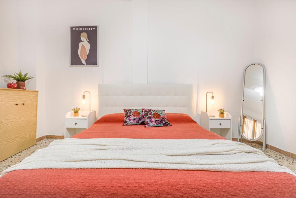 - une chambre dotée d'un grand lit avec des draps orange et un miroir dans l'établissement Appartamento zona Centro-Pomposa WiFi&Netflix, à Modène