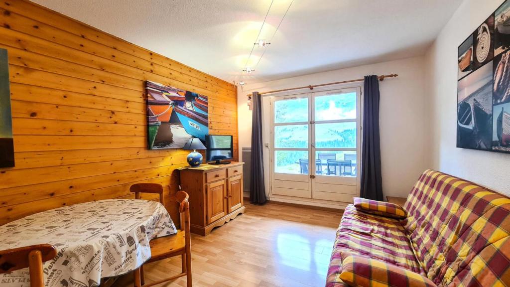 ein Wohnzimmer mit einem Tisch und einem Sofa in der Unterkunft Chalet De L'arbaron - Studio pour 4 Personnes 92 in Flaine