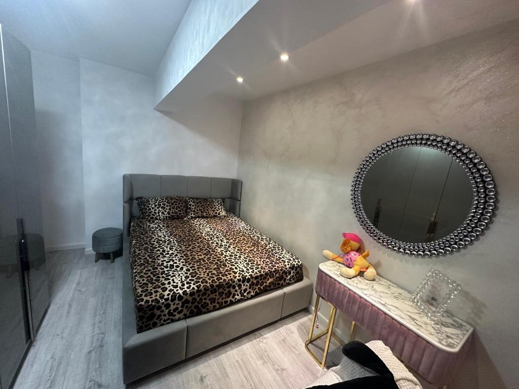 Cette chambre comprend un lit avec un miroir et une table. dans l'établissement Apartament Chloe, à Tulcea