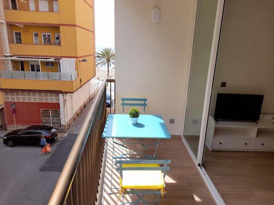 un tavolo blu sul balcone di un edificio di Apartamento Playa Paseo Marítimo Almería a Almería